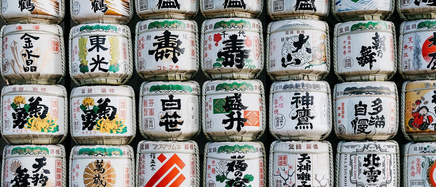 Kazaridaru, ceremonial sake barrels, each bearing its brewery's mark