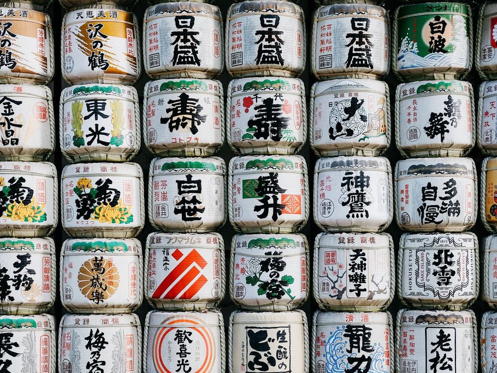 Kazaridaru, ceremonial sake barrels, each bearing its brewery's mark